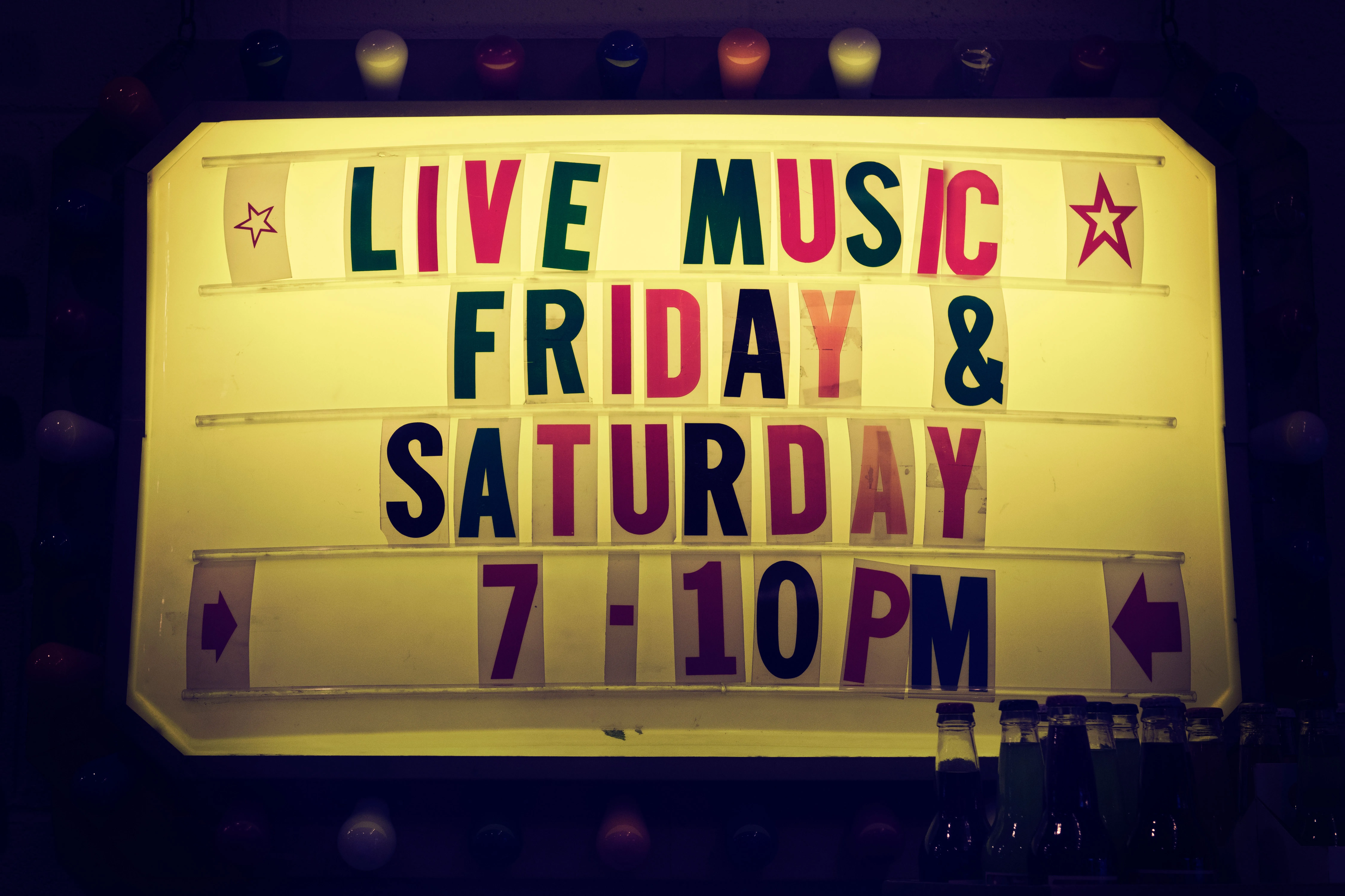 Theater-style illuminated sign advertising music Friday and Saturday